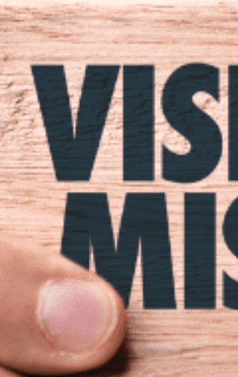 Man holding paper saying 'Vision' and 'Mission'