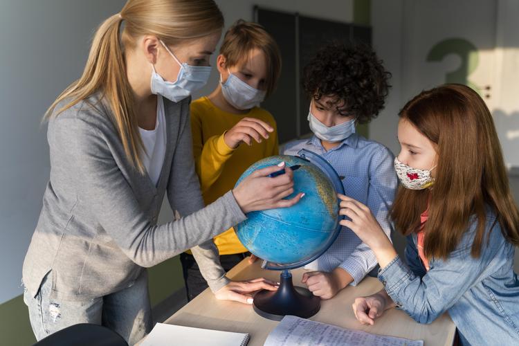 Female Teacher Teaching Geography With Earth Globe